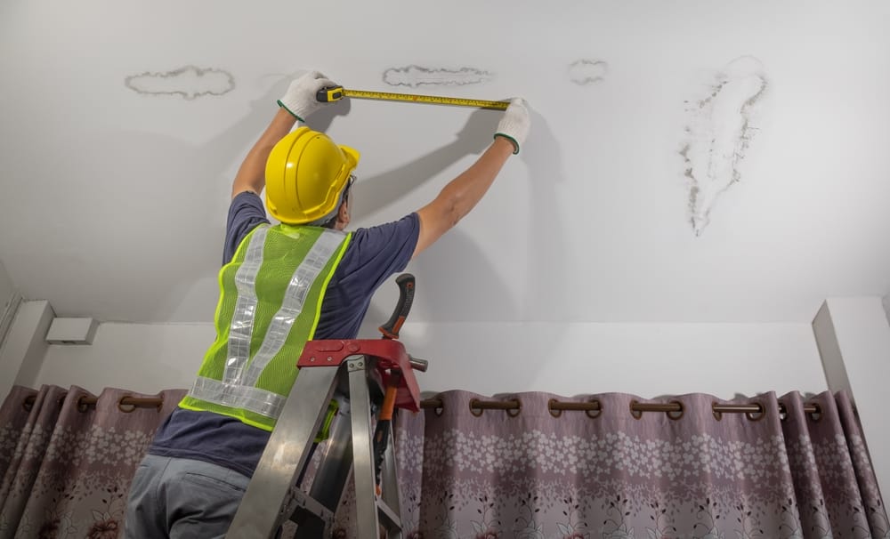 worker,fix,leaking,pipe,in,ceiling,,close up,of,a,stain