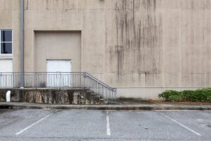 stairs,and,handrail,to,entrance,to,concrete,building,with,mold