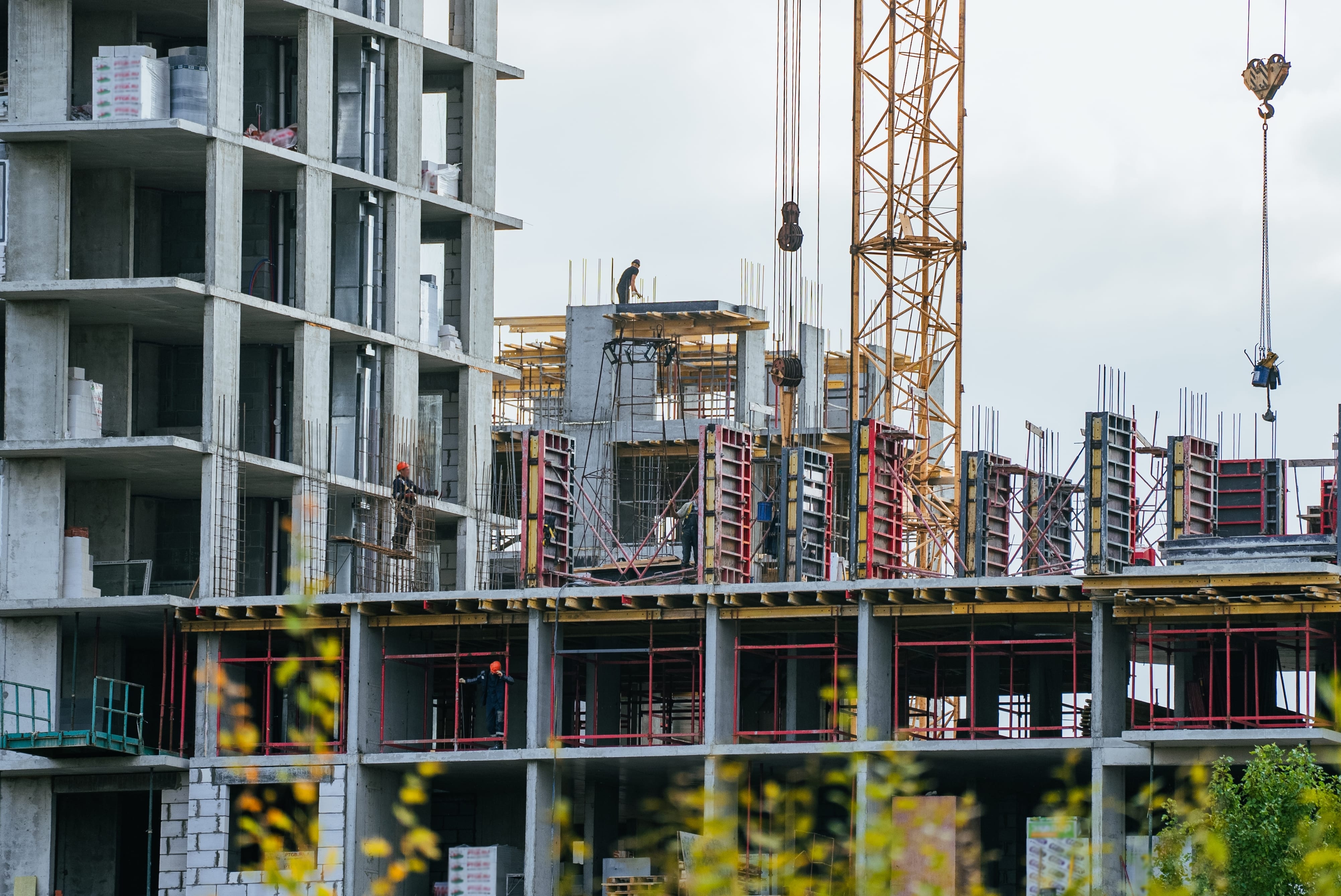 construction,workers,efficiently,building,a,large,concrete,residential,building,,using